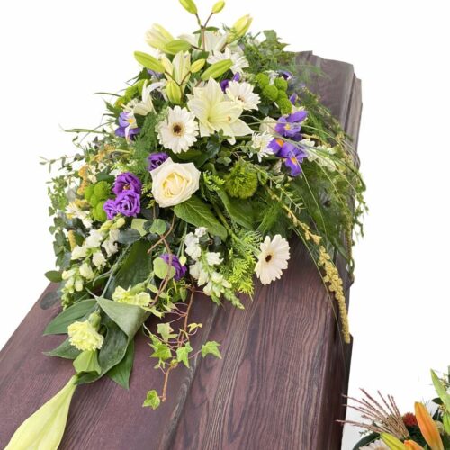 Sargschmuck in weiß auf einem dunklem Sarg