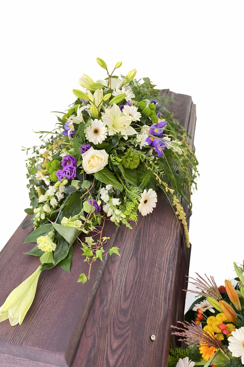 Sargschmuck in weiß auf einem dunklem Sarg