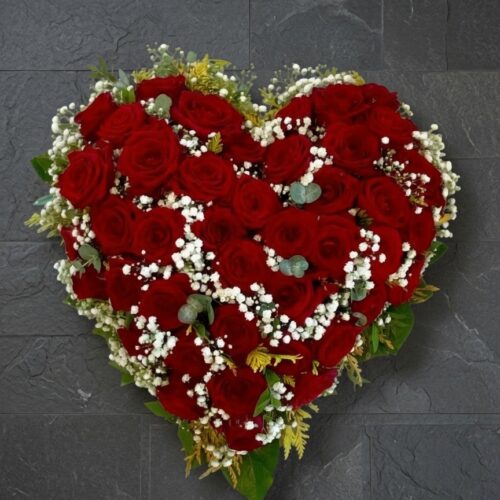 Herzgesteck aus roten Rosen auf einer Schieferplatte zur Beerdigung