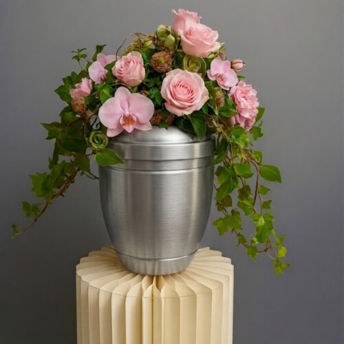 Urne mit Blumenschmuck in rosa